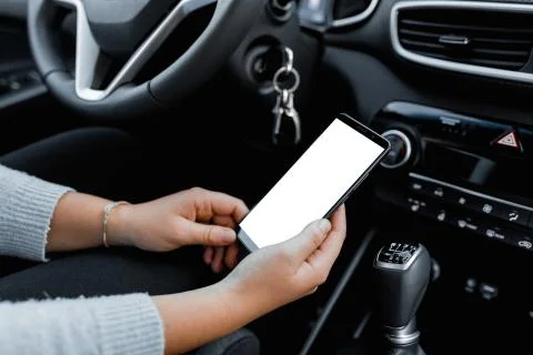 Young driver using smartphon in the car while driving or parking. Mockup of a Stock Photos