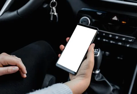 Young driver using smartphon in the car while driving or parking. Mockup of a Stock Photos