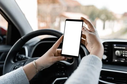Young driver using smartphon in the car while driving or parking. Mockup of a Stock Photos