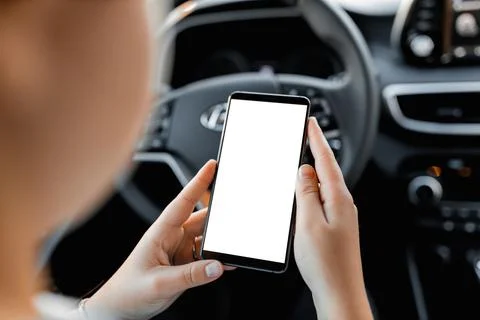 Young driver using smartphon in the car while driving or parking. Mockup of a Stock Photos