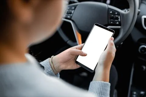 Young driver using smartphon in the car while driving or parking. Mockup of a Stock Photos