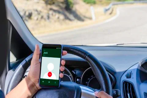 Young driver, using smartphone, on the road in the car. 写真素材