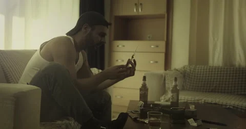 Young Drug Addict Man Loading Syringe Needle For Injection On Dingy Sofa Video stock 143169787