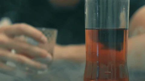 Young drunk man drinks whiskey from a glass and falls asleep on the table, a Video stock 111961181