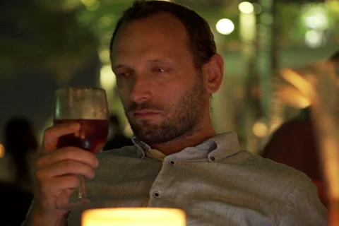Young drunk man sitting in bar during night NTSC Stock Footage 51877423