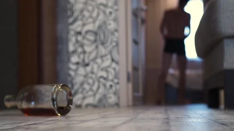 A young drunk man walks staggering around the house. Stock Footage 100626416