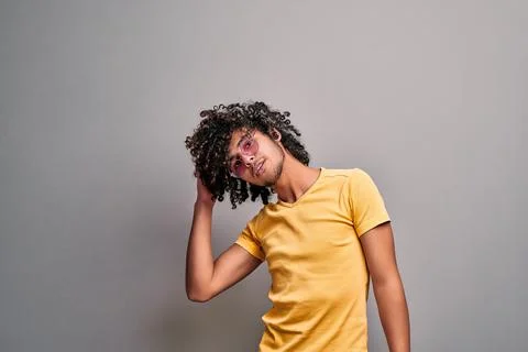 Young eastern man playfully touching his healthy beautiful curly hair Stock Photos