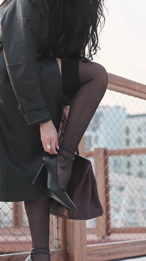 Young efficient long-haired brunette adjusting high heels. Stock Footage 309168934