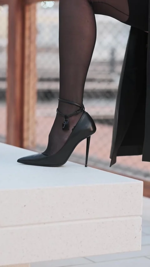 Young efficient long-haired brunette adjusting high heels. Stock Footage 334541346
