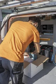 Young electricians loading work van with tools and materials before startin.. Stock Photos