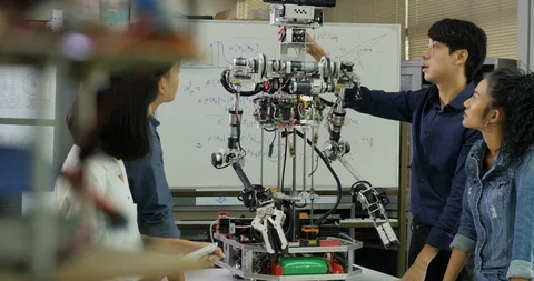 Young electronics engineer team collaborating on construction of robot in the Stock Footage 94542327