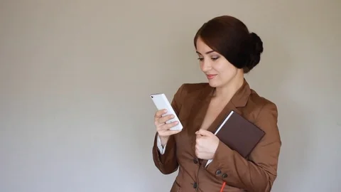 Young Elegant beautiful businesswoman smiling and texting on smartphone. The Stock Footage