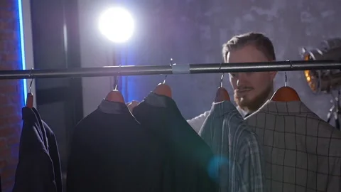 Young elegant man chooses classic suit in store Stock Footage 103029862