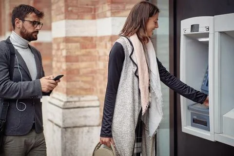 A young elegant man is impatient while waiting in a row for cash machine. W.. Stock Photos