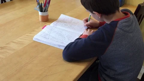 Young elementary school boy hand writing homework Stock Footage 128616269