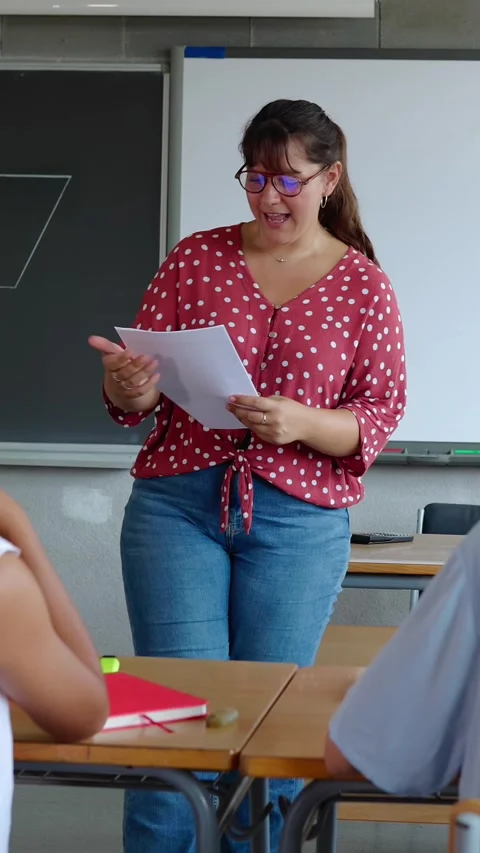 Young elementary school teacher explaining exercises to her pupils at school. Vídeo Stock 312198283