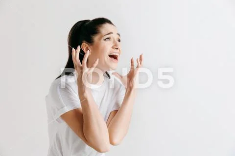 The young emotional angry woman screaming on gray studio background Stock Photos