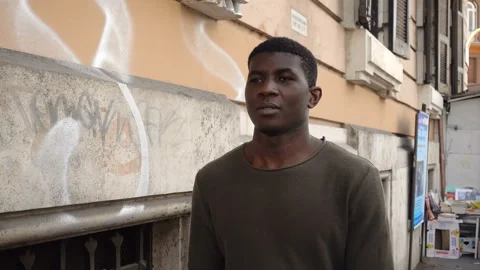 Young employed black man walking on the street with a pensive look Stock Footage 133439017