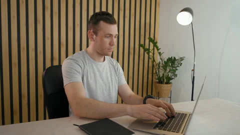 Young employee types report on modern laptop sitting at desk Stock Footage 201239201