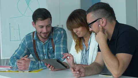 Young employees read funny posts on the tablet. Stock Footage 93866192