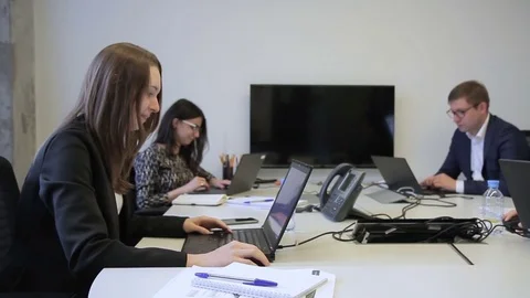 Young employees working at desk with laptops sitting in company. Stock Footage 83107257