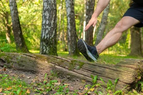 A young enduring athletic athlete is doing stretching in the forest outdoors Foto stock