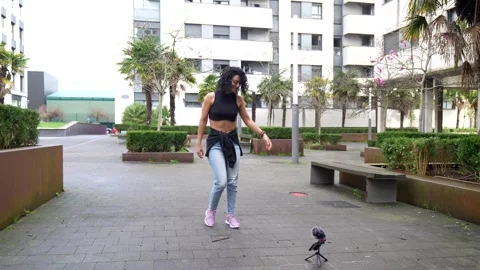 Young energetic dancer recording herself performing outdoors Stock Footage 303060569