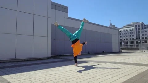Young energetic guy dancer breakdancing outdoors and jumping on hand Stock Footage 293839870