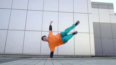 Young energetic guy dancer breakdancing outdoors in the city on the street Stock Footage 293839968