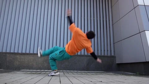 Young energetic guy dancer breakdancing outdoors in the city on the street Stock Footage 295068905