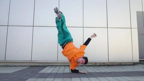 Young energetic guy dancer breakdancing outdoors in the city on the street Stock Footage 295068972