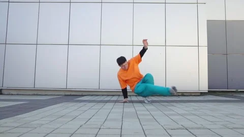 Young energetic guy dancer breakdancing outdoors in the city on the street Stock Footage 295068986