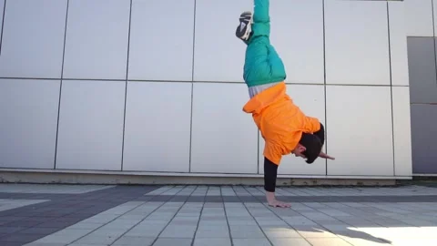 Young energetic guy dancer breakdancing outdoors in the city on the street Stock Footage 295069092