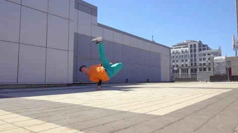 Young energetic guy dancer breakdancing outdoors in the city on the street Stock Footage 295069126