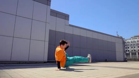 Young energetic guy dancer breakdancing outdoors in the city on the street Stock Footage 295069137