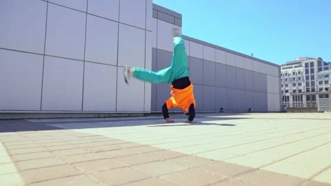 Young energetic guy dancer breakdancing outdoors in the city on the street Stock Footage 295069154