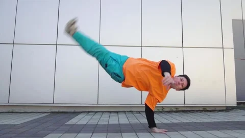 Young energetic guy dancer breakdancing outdoors in the city on the street Stock Footage 295685573