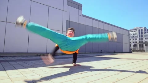 Young energetic guy dancer breakdancing outdoors in the city on the street Stock Footage 295685604