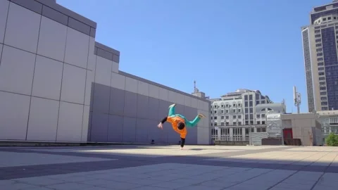 Young energetic guy dancer breaksdancing outdoors in the city on the street Stock Footage 293839919