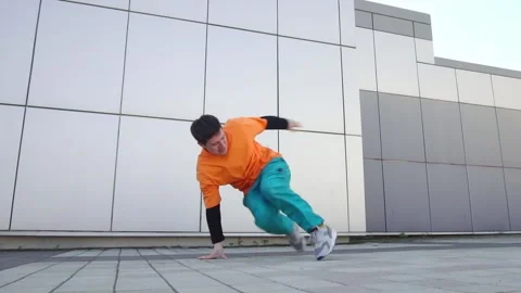 Young energetic guy dancer breaksdancing outdoors in the city on the street Stock Footage 293839996