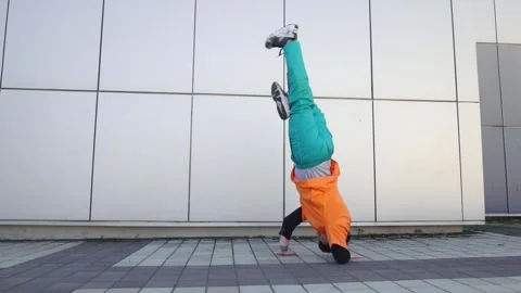 Young energetic guy dancer breaksdancing outdoors in the city on the street Stock Footage 295068987