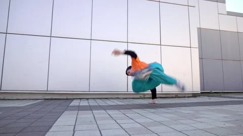 Young energetic guy dancer breaksdancing outdoors in the city on the street Stock Footage 295069090