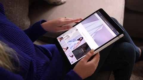 Young Engaged Blonde Female Browsing Internet Page For A Wedding Dress On Tablet Stock Footage 147623341