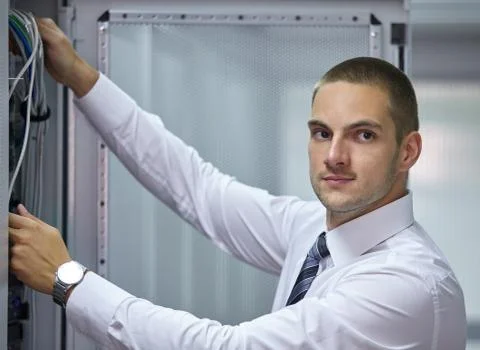 Young engeneer in a modern datacenter server room Stock Photos