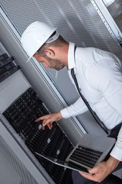 Young engeneer in a modern datacenter server room Stock Photos
