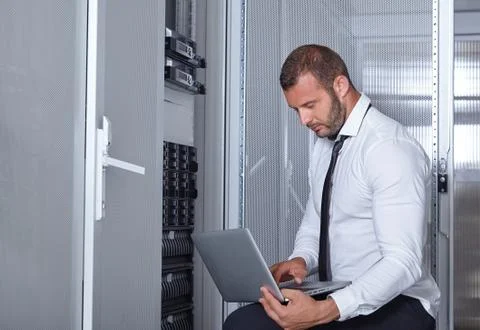 Young engeneer in a modern datacenter server room Stock Photos