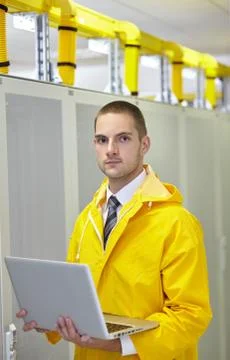 Young engeneer in a modern datacenter server room Stock Photos