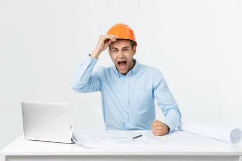 Young Engineer angry during working with laptop in office building site, h... Stock Photos