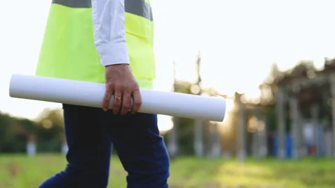 Young engineer architect or builder holding blueprint in his hand in front of Stock-Footage 194622560