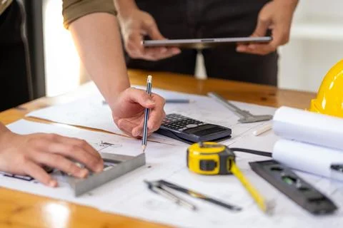 Young engineer architect sketching drawing project plan building construction Fotos de archivo
